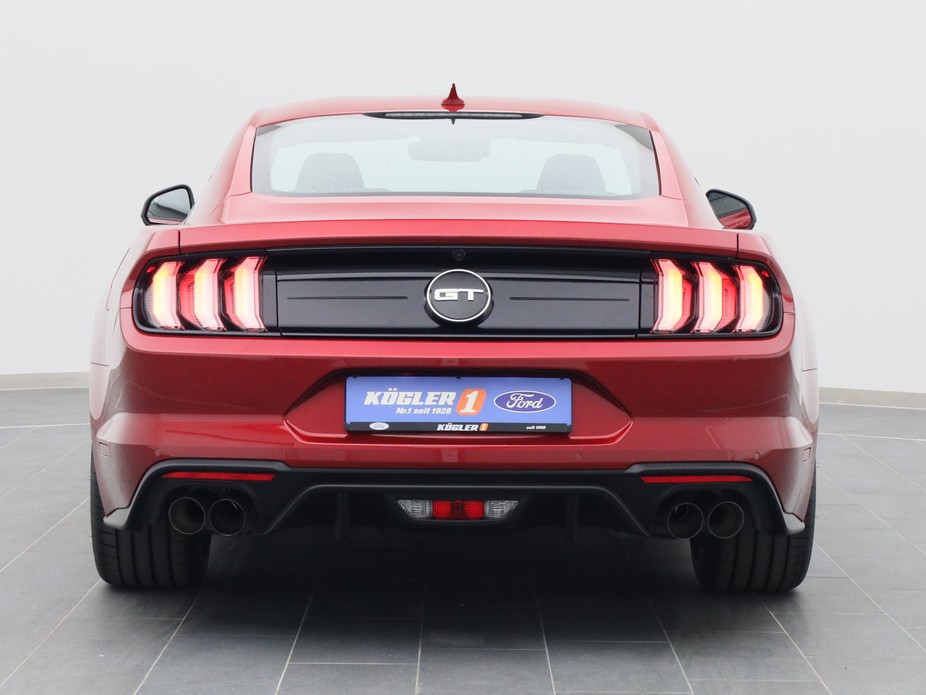Heckansicht eines Ford Mustang GT Coupé V8 450PS / Premium 2 / B&O in Lucid Rot 