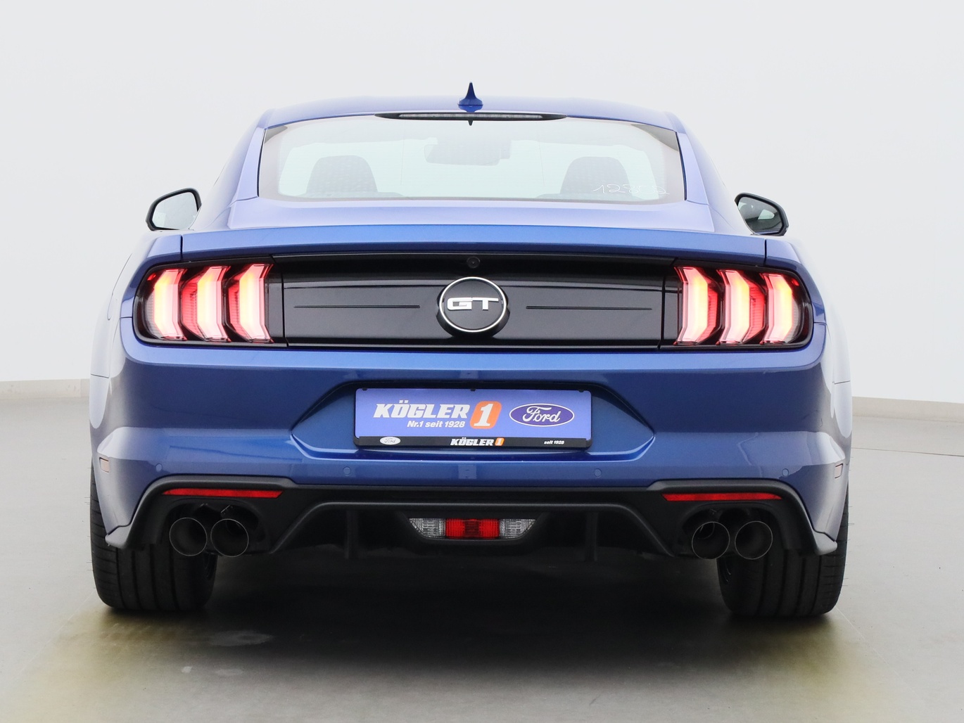 Heckansicht eines Ford Mustang GT Coupé V8 450PS / Premium 2 / B&O in Atlas Blau 