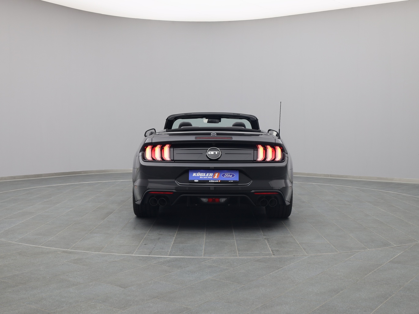 Heckansicht eines Ford Mustang GT Cabrio V8 450PS / Premium 2 / Magne in Dark Matter Grey 