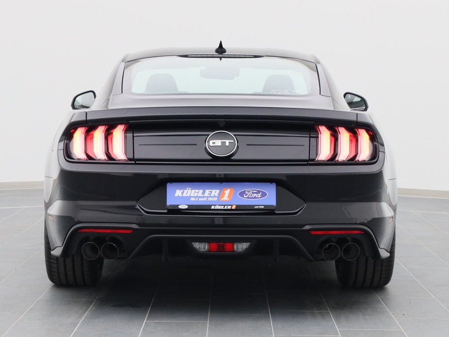 Heckansicht eines Ford Mustang GT Coupé V8 450PS / Premium 3 / B&O in Iridium Schwarz 