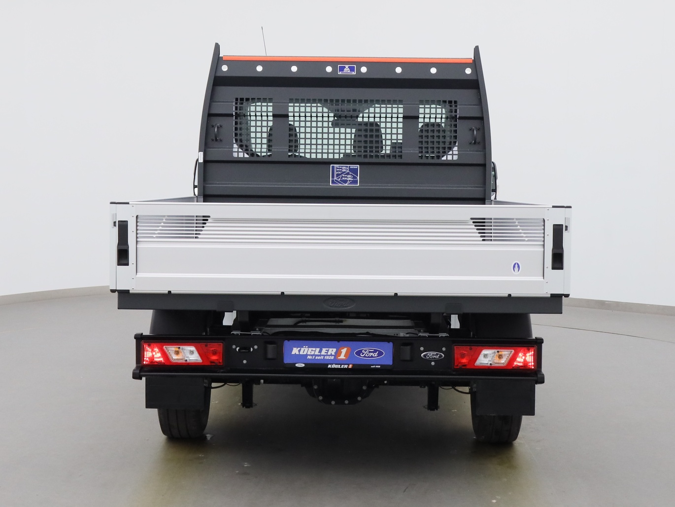 Heckansicht eines Ford Transit Pritsche EK 330 L1 Trend Hybrid HA in Weiss 