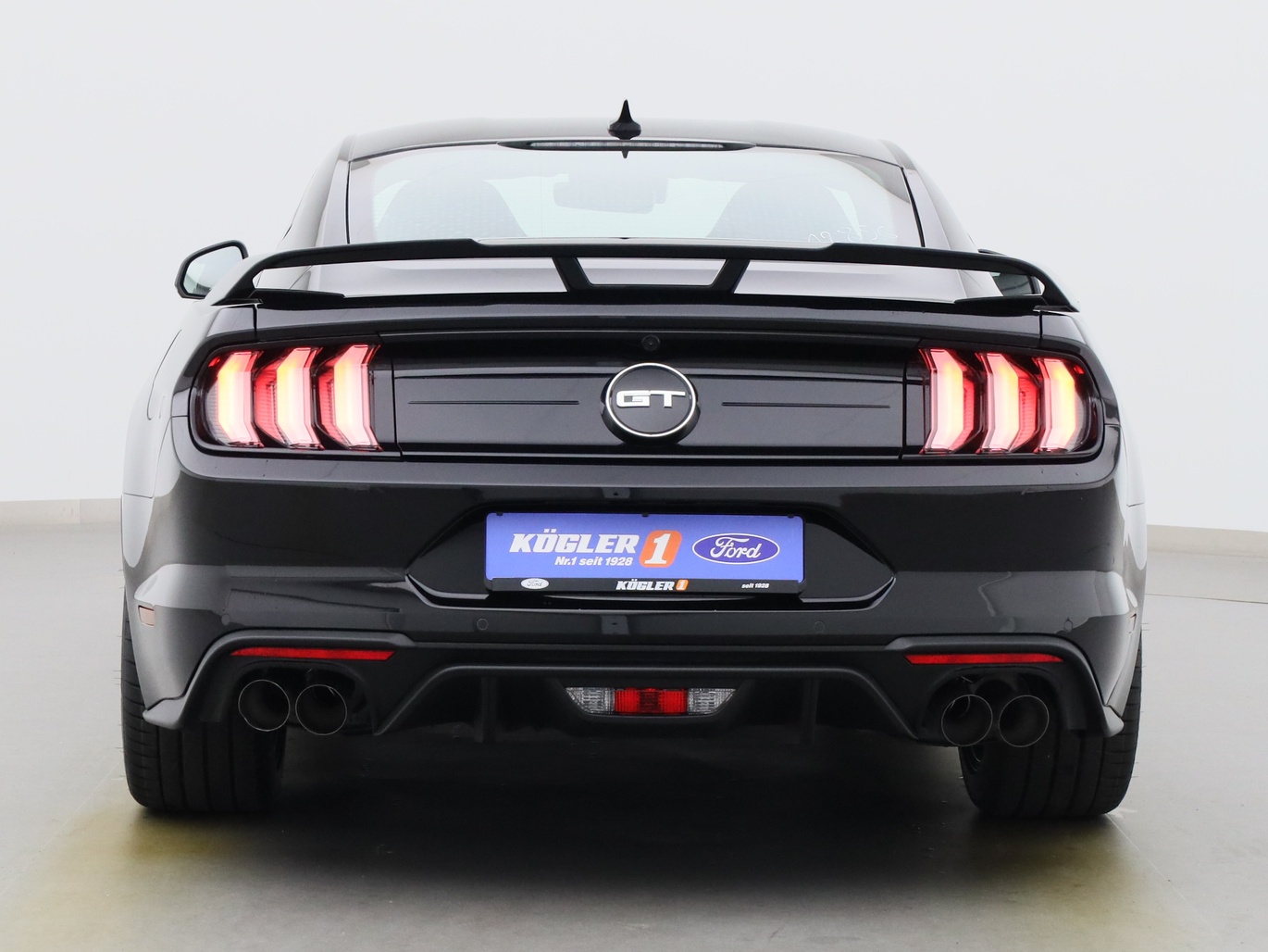 Heckansicht eines Ford Mustang GT Coupé V8 450PS / Premium 2 / Magne in Iridium Schwarz 