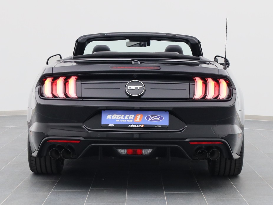 Heckansicht eines Ford Mustang GT Cabrio V8 450PS / Premium 2 / Magne in Iridium Schwarz 
