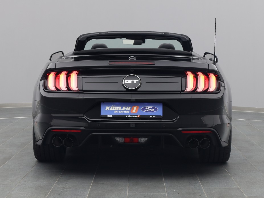Heckansicht eines Ford Mustang GT Cabrio V8 450PS / Premium 2 / Magne in Iridium Schwarz 