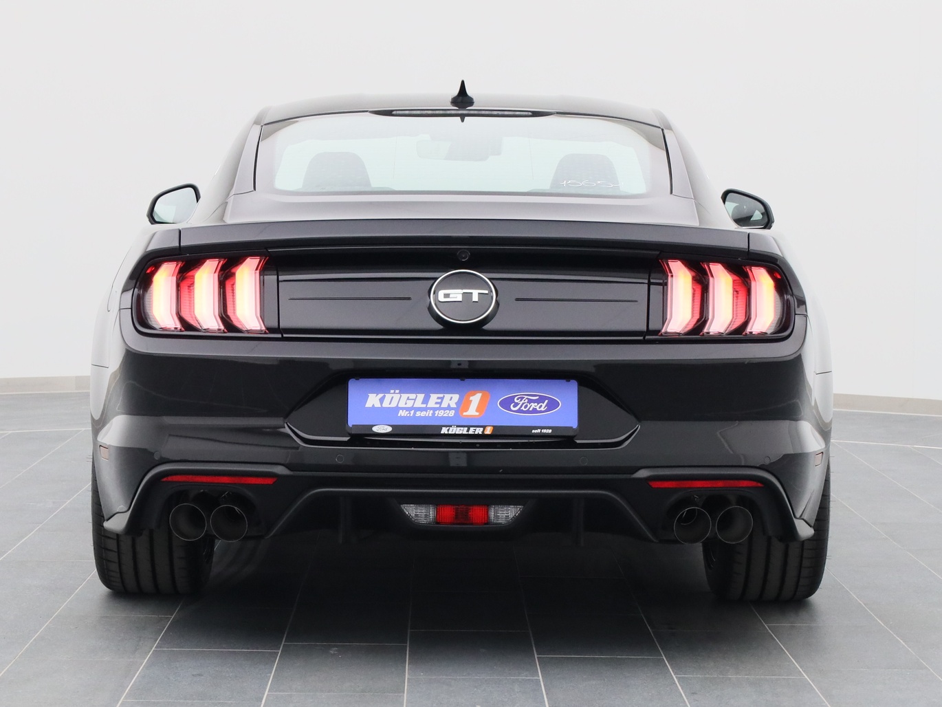 Heckansicht eines Ford Mustang GT Coupé V8 450PS / Premium 3 / Magne in Iridium Schwarz 