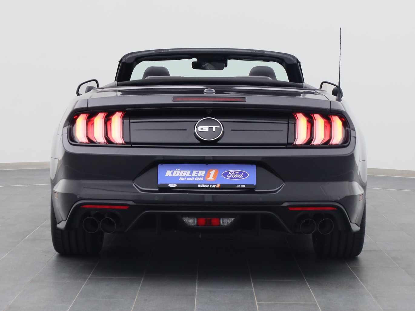 Heckansicht eines Ford Mustang GT Cabrio V8 450PS / Premium 2 / B&O in Dark Matter Grey 