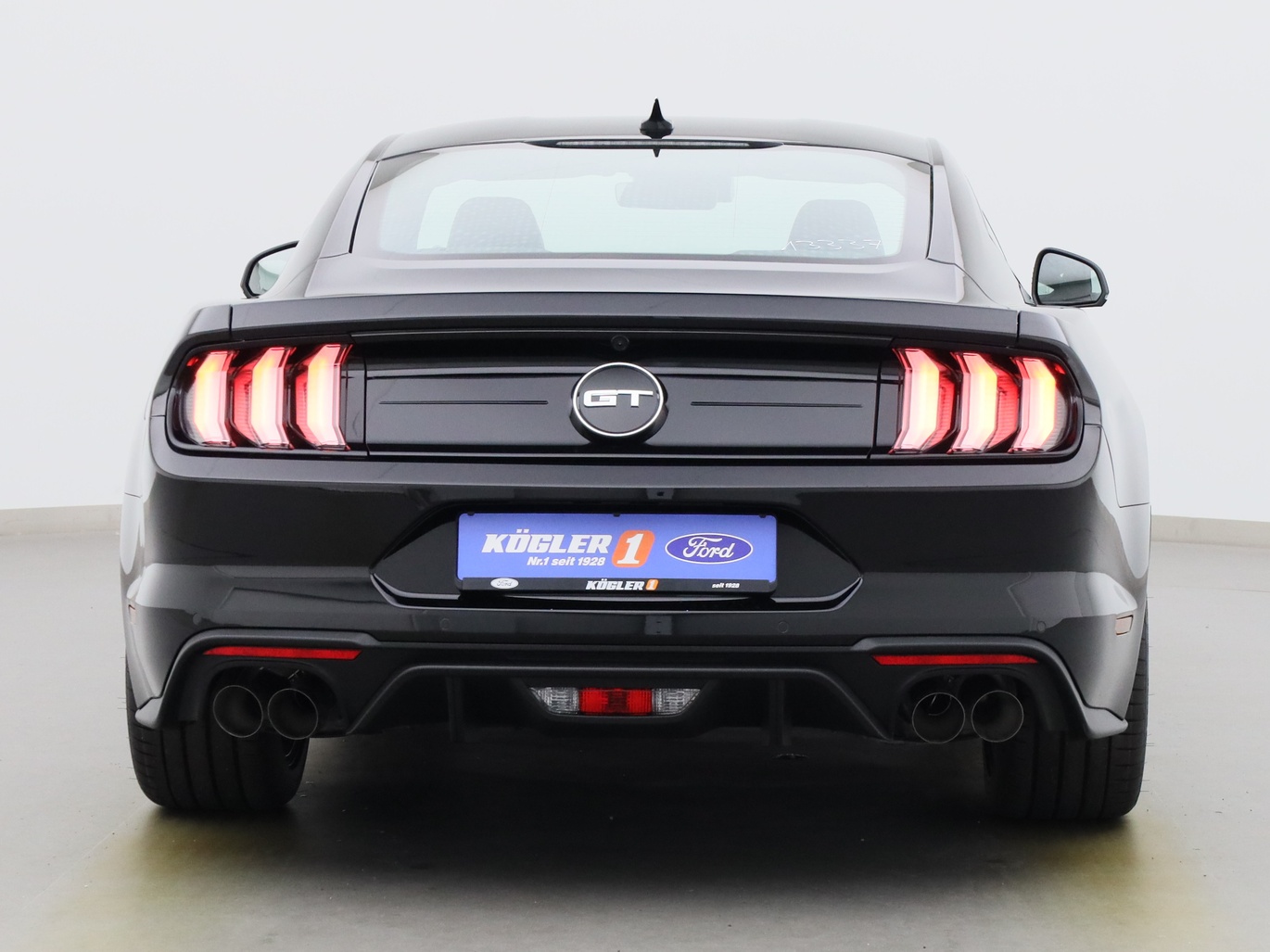 Heckansicht eines Ford Mustang GT Coupé V8 450PS / Premium 2 / B&O in Iridium Schwarz 