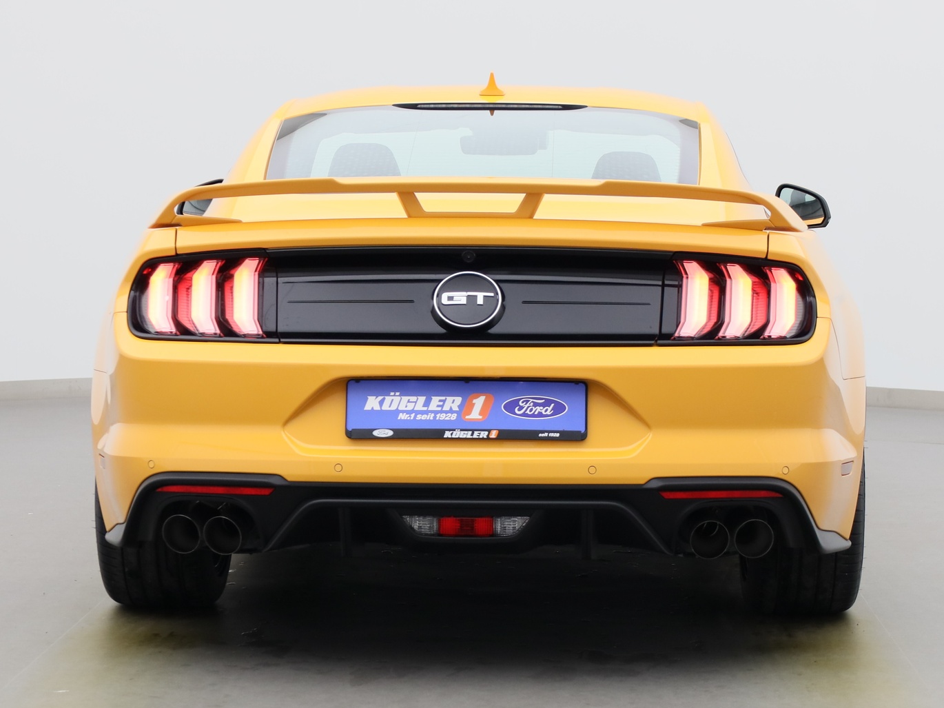 Heckansicht eines Ford Mustang GT Coupé V8 450PS / Premium 2 / Magne in Cyber Orange 