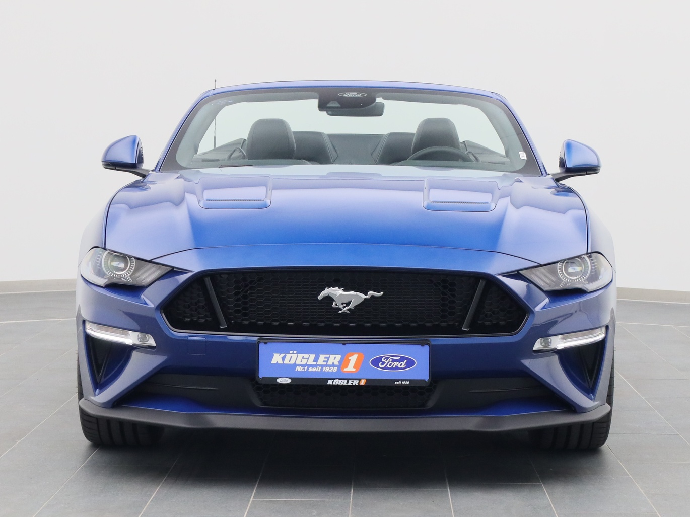 Frontansicht eines Ford Mustang GT Cabrio V8 450PS / Premium 2 / Magne in Atlas Blau 
