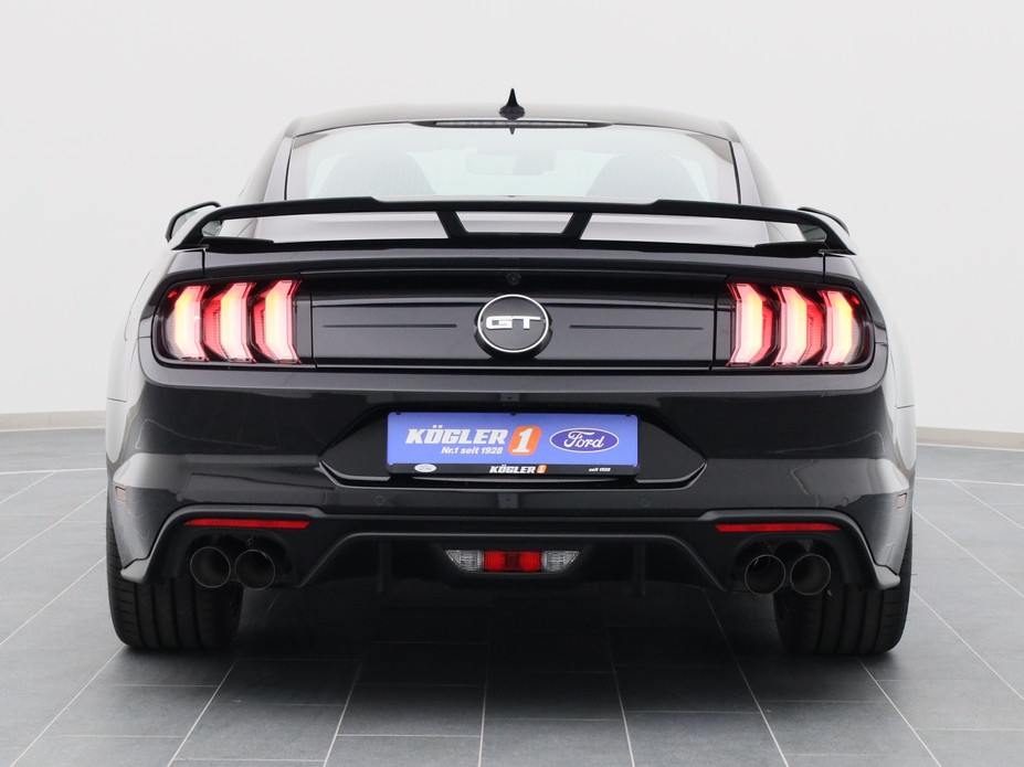 Heckansicht eines Ford Mustang GT Coupé V8 450PS / Premium 2 / Magne in Iridium Schwarz 