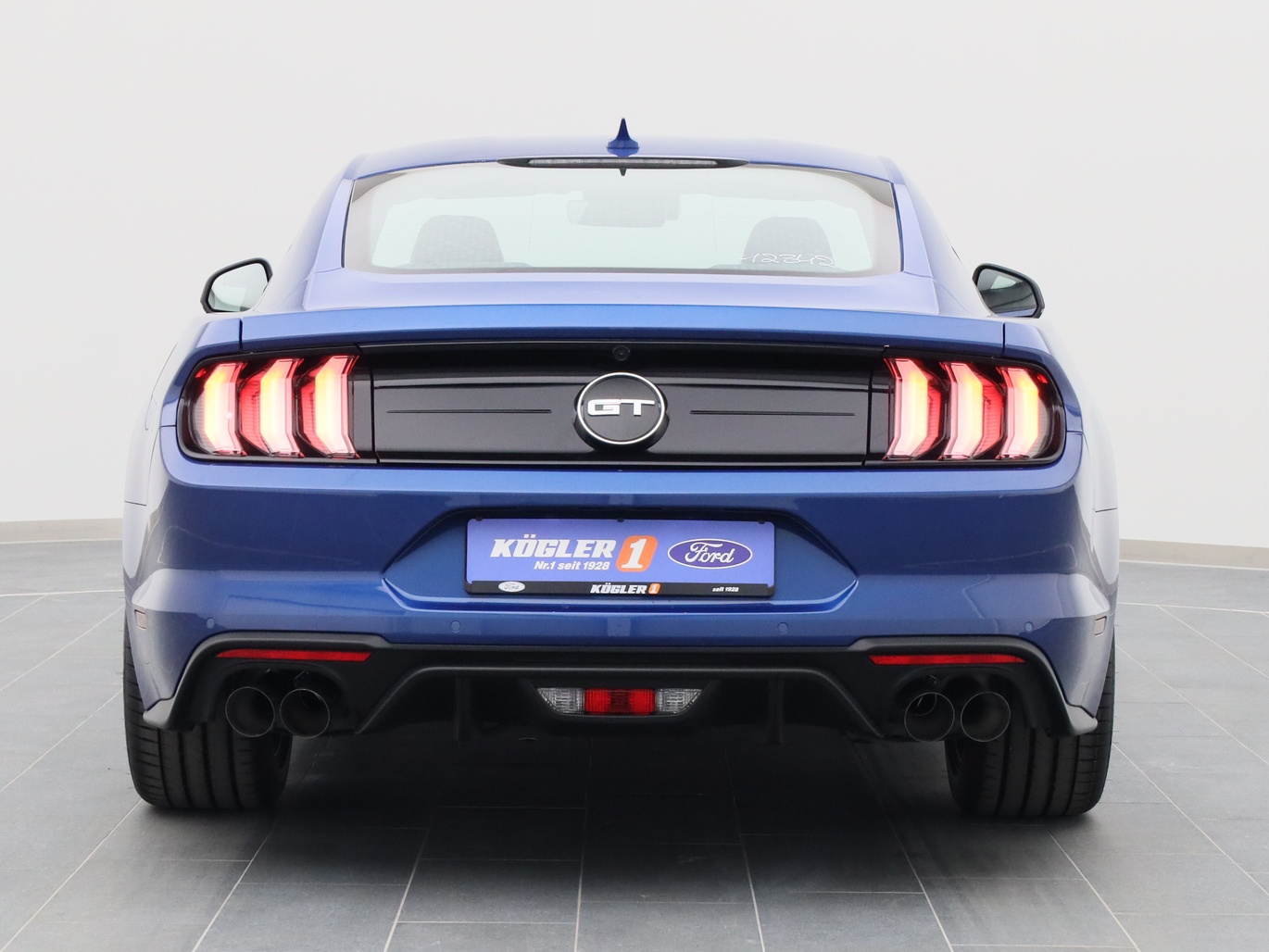 Heckansicht eines Ford Mustang GT Coupé V8 450PS / Premium 2 / B&O in Atlas Blau 