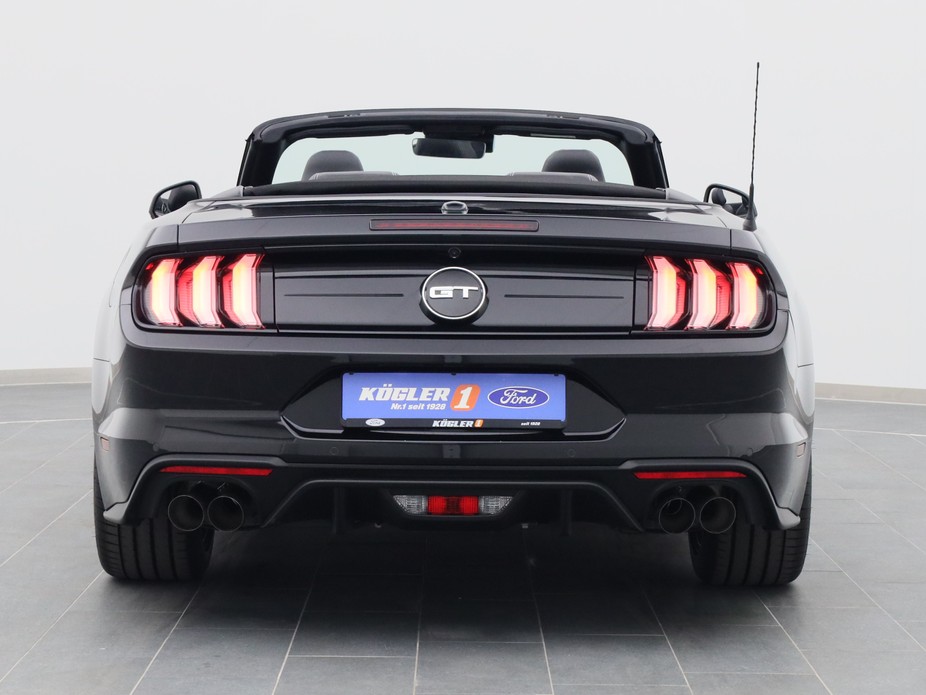 Heckansicht eines Ford Mustang GT Cabrio V8 450PS / Premium 2 / B&O in Iridium Schwarz 